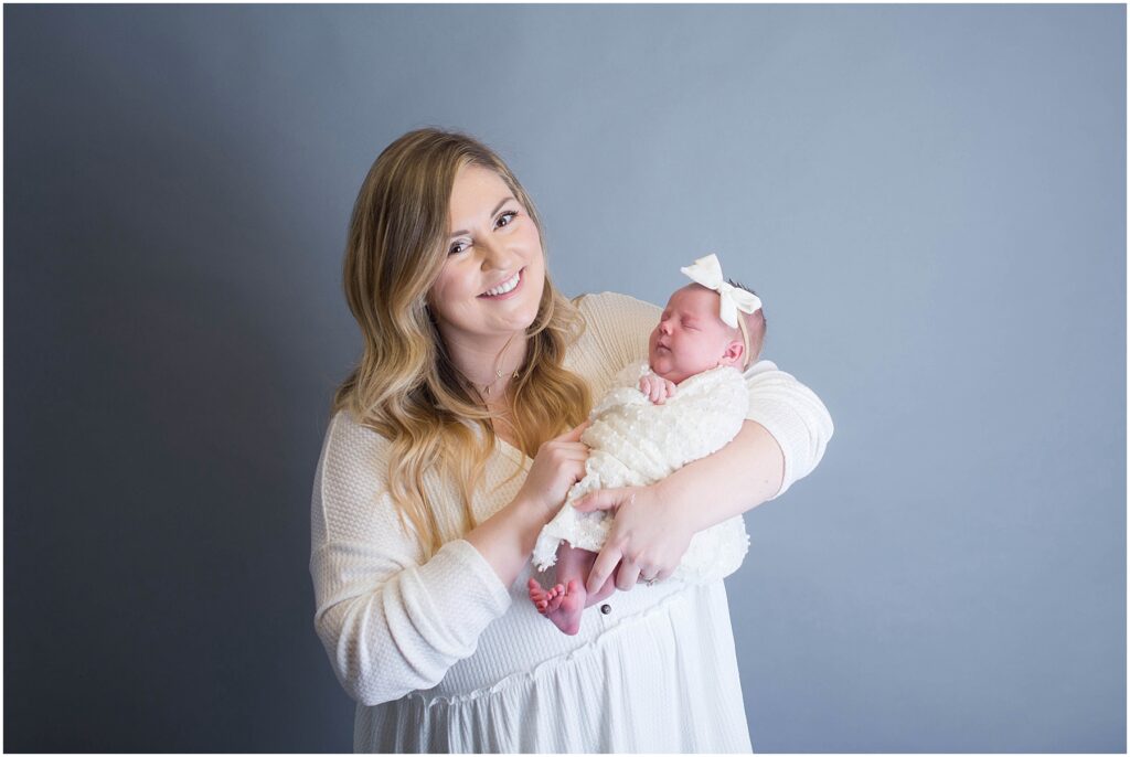 new baby with headband in mothers arms